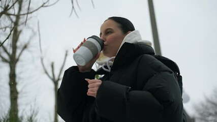 A cute girl is standing in the cold.
Snow flies outside.
The girl rejoices in the snow.
A young girl in a hood is standing on the street.
Girl walking in the snow