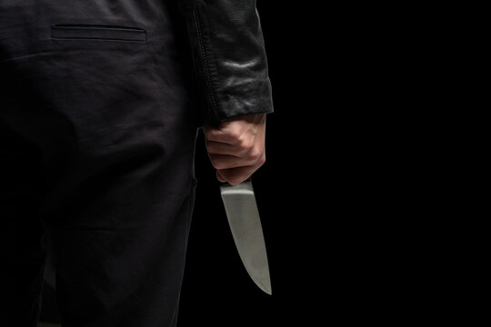 Criminal holding a knife closeup, armed attack concept.
