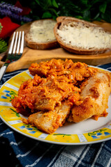 Fish in Greek kind with vegetables and tomato sauce.