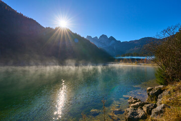 Beautiful sunset on Gosaub lake. Sunset sun and fog. Salzkammergut region.