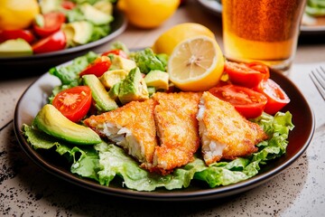 Delicious battered fish served on a bed of fresh greens with tomatoes and tangy lemon slices