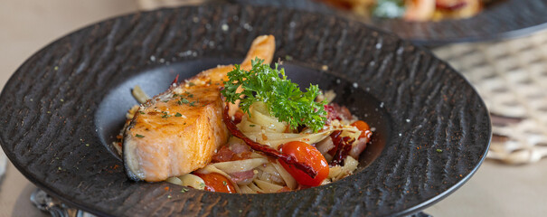 Grilled salmon and fettuccine. Italian fettuccine with salmon and herbs. Spaghetti salmon steak and herbs in Black plate. grilled salmon fillet with spaghetti