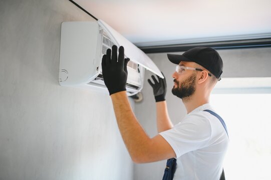Repairman fix air conditioning systems, Male technicians service for repair and maintenance of air conditioners, Air conditioning technicians install new air conditioners in homes