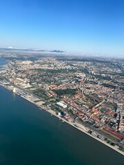 Fototapeta premium Belem, Lisbon, Portugal - 26th April 2024 - Aerial view of historic Belem district along Tagus River, featuring iconic MAAT museum, maritime promenade, and mix of modern and historic architecture.