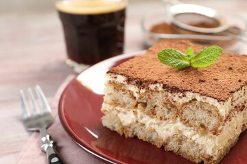Delicious tiramisu with mint on light wooden table, closeup