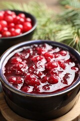 Tasty cranberry sauce in bowl on table, closeup