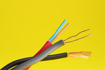 Many stripped electrical wires on yellow background, closeup