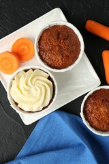 Tasty carrot muffins with fresh vegetables on grey table, flat lay