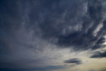 Dark gray-blue clouds cover the sky to the horizon, an impending storm, weather change, winter sky.