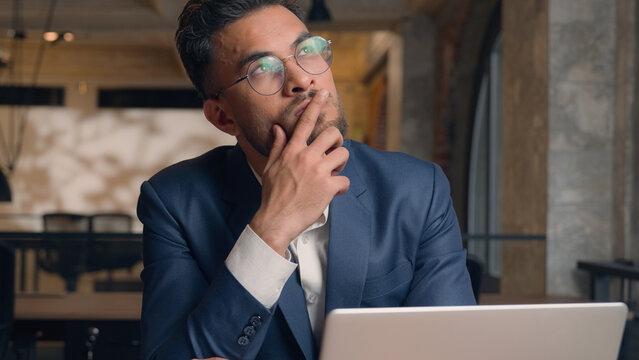 Thoughtful puzzled businessman Arabian Indian man thinking male guy employer worker think idea business plan strategy ponder consider doubt choose remember decide search deep thought question indoors - Powered by Adobe