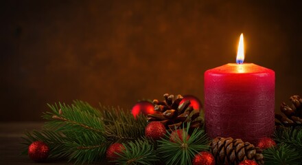 A red candle on dark, rich brown background with the warm, golden tones of the Christmas decorations Surrounding the candle are various Christmas elements