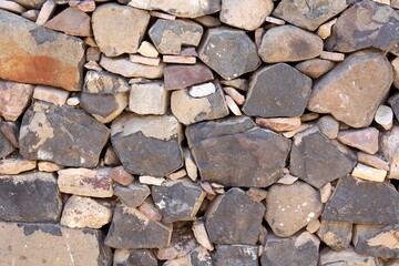Stone wall texture background - grey ,white, orange stone siding with different sized stones