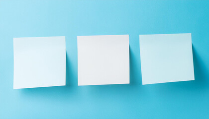 Three empty sticky notes on pastel blue background. Blank paper for message. Mock-up. Close-up.