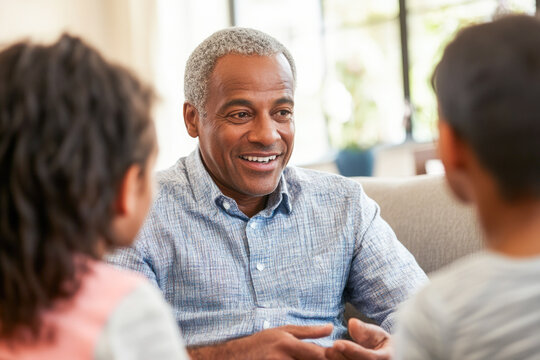Elderly african male engaging with children in comfortable living room setting