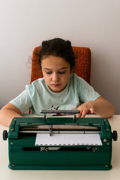 Typing on a braille machine. Children's hands on the machine in close-up. Training of blind people. Learning to write.