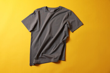 One grey t-shirt on yellow background, top view
