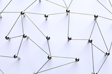 Network connection. Nails linked together by threads on white background, flat lay