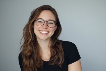 Obraz premium Smiling woman with long hair and glasses radiates joy in studio setting during bright morning, showcasing natural beauty and inspiring warmth