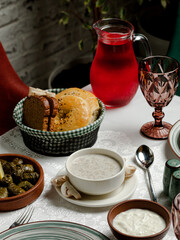 Azerbaijani table serving. Bread, mushroom soup, compote, dolma