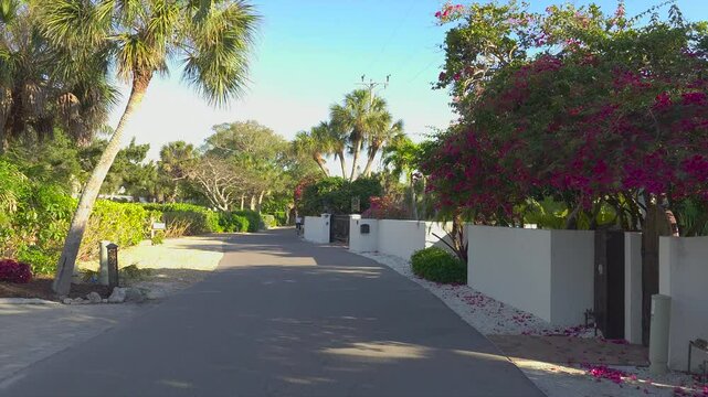 Casey Key coastal residential community picturesque street. Car point of view driving on scenic road in sunny Florida.
