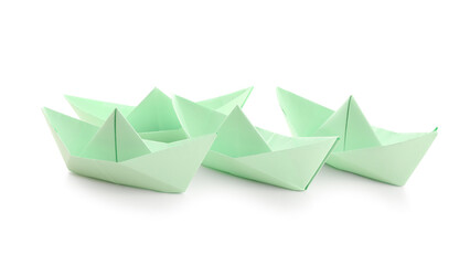 Green origami boats on white background