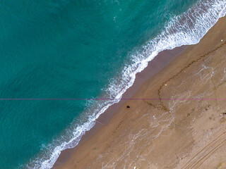 Summer advertisement background Aerial View of Turquoise Water Meeting Sandy Beach with Heart Shape in the Sand. High-angle, full shot of a turquoise ocean meeting a sandy beach. Karasu Sakarya Turkey