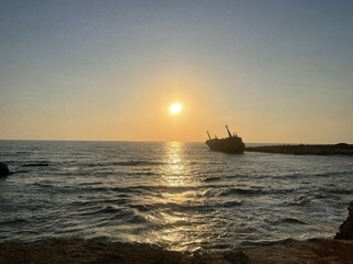 Obraz premium Shipwreck at Sunset with Golden Reflections on the Calm Sea in Pegeia, Paphos, Cyprus