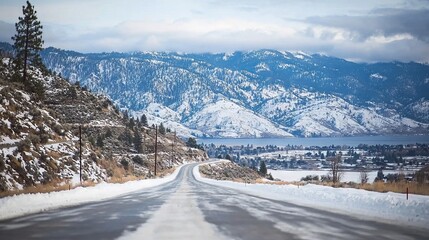 Snow-covered road winding through a mountainous landscape.