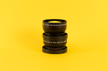 bunch of lenses from a professional camera in a yellow background