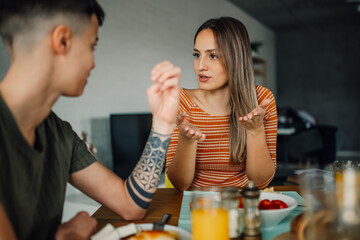Lesbian couple having breakfast and talking at home