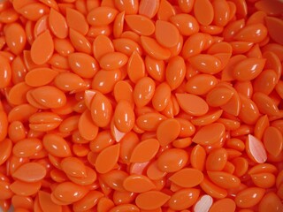 Background orange wax in depilatory granules close-up