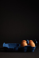 Brown Chicken egg on black background. Packaging. Free space.