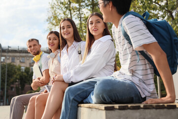 Group of students sitting on bench near university