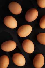Chicken eggs on black background. View from the top