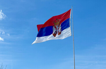 Serbian national flag waving on wind in a bright sunny weather