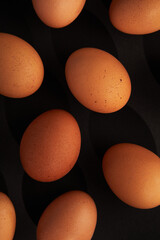 Chicken eggs on black background. View from the top