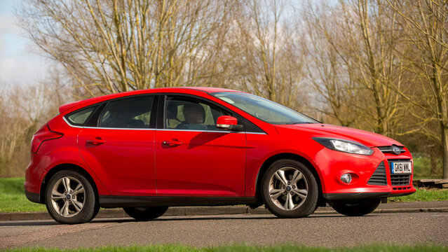 2011 red Ford Focus car driving on an English road