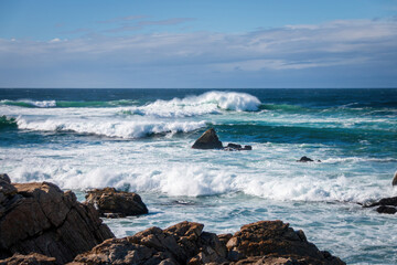 Scenic view of Pacific Ocean waves at the coast seen from Spanish Bay Vista Point, Del Monte Forest, California, USA against blue sky with clouds