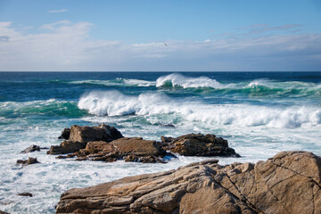 Scenic view of Pacific Ocean waves at the coast seen from Spanish Bay Vista Point, Del Monte Forest, California, USA against blue sky with clouds