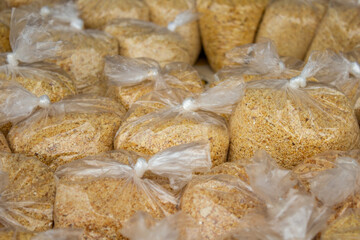 Close up em lguns saquinhos plásticos com farinha de mandioca expostos para venda em um comércio local.