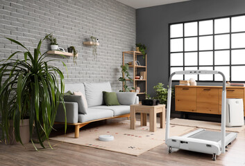 Interior of living room with sofa, treadmill and appliances