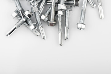 Screwdriver with a screw attachment. Self-tapping screws for metal on a white background.