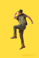 Jumping male traveler on yellow background