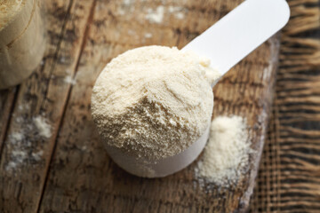 Whey protein powder in a white measuring cup