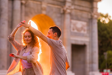 Couple dancing swing in front of puerta de alcala in madrid at sunset