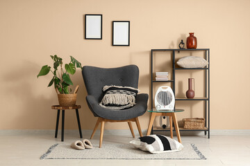 Interior of stylish living room with modern electric fan heater and grey armchair