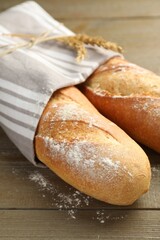 Freshly baked baguettes on wooden table, closeup