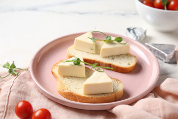 Plate with bread, triangles of tasty processed cheese and tomatoes on light background