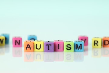 Word Autism made of colorful cubes on light background