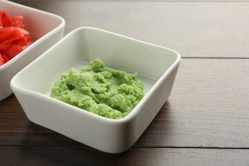 Hot wasabi paste and ginger on wooden table, closeup